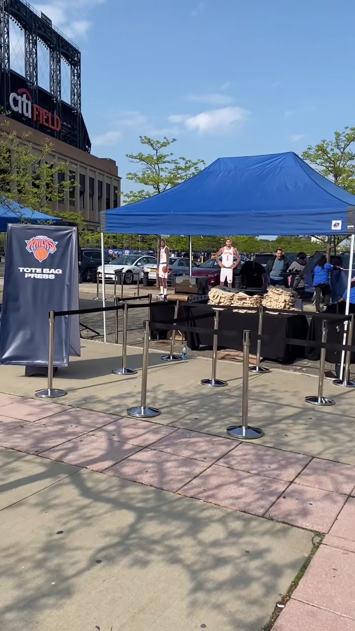 Wide shot of the Knicks Tote Bag Press outdoor setup with the queue lanes laid out in front of the tent