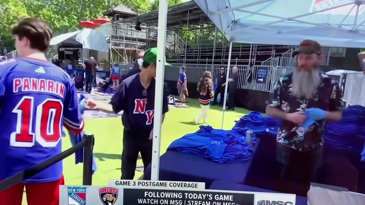 A frame from MSG's postgame coverage of the activation — a fan in a Panarin jersey at the station while the crew hands out printed shirts