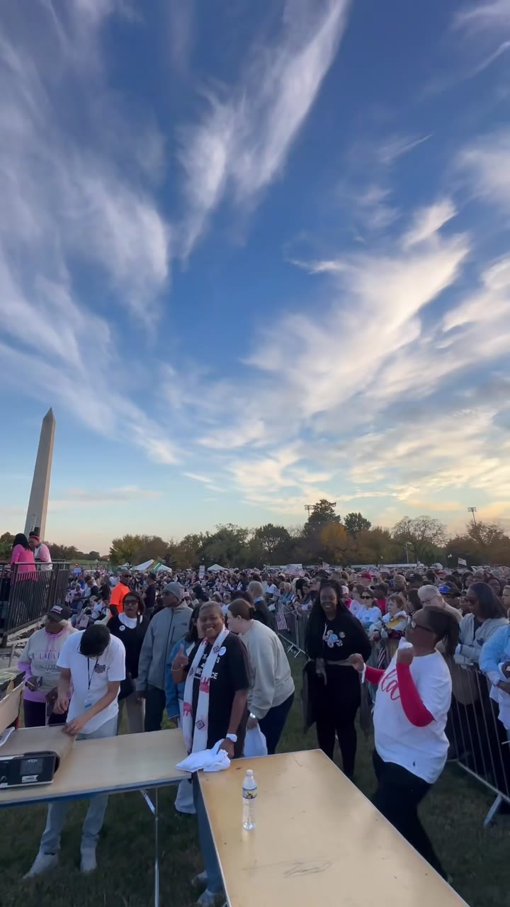 The rally crowd stretching out under a big sunset sky, the Washington Monument at the edge and the station tables in front