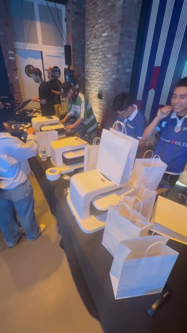 A row of three compact lasers working an event line, guests waiting with gift bags