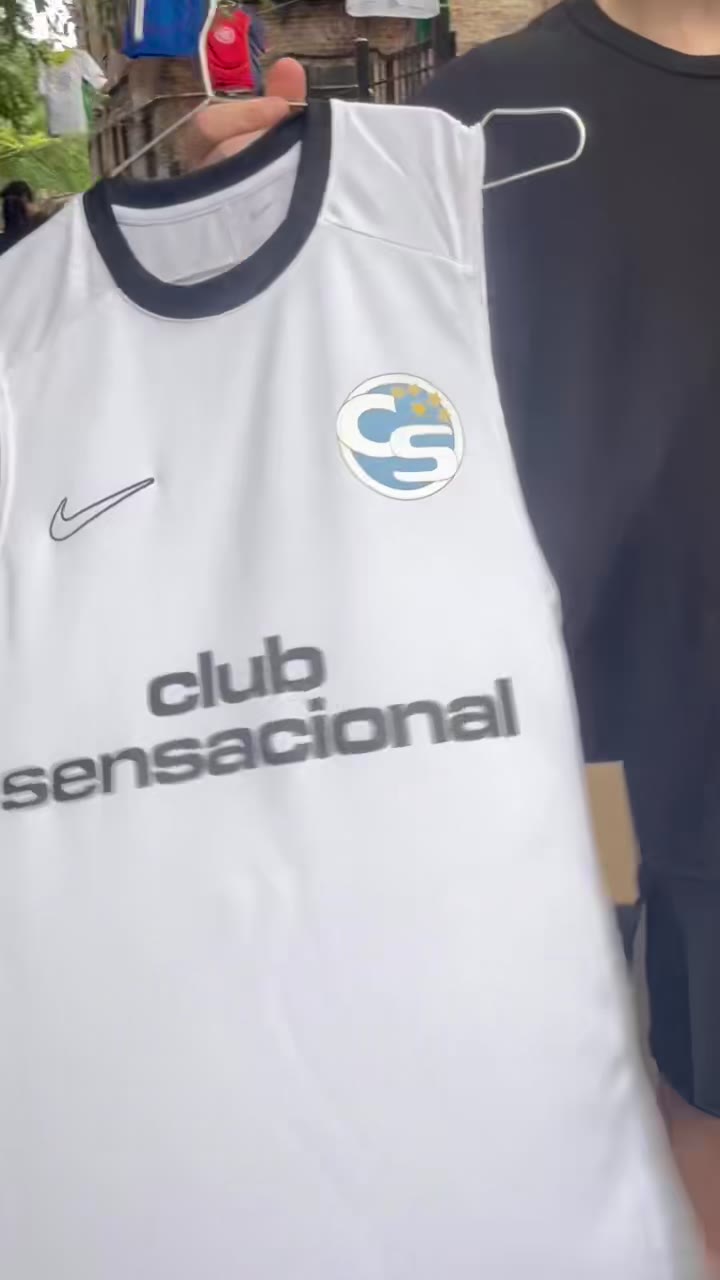 A finished white Nike jersey — club sensacional — held up at an outdoor event